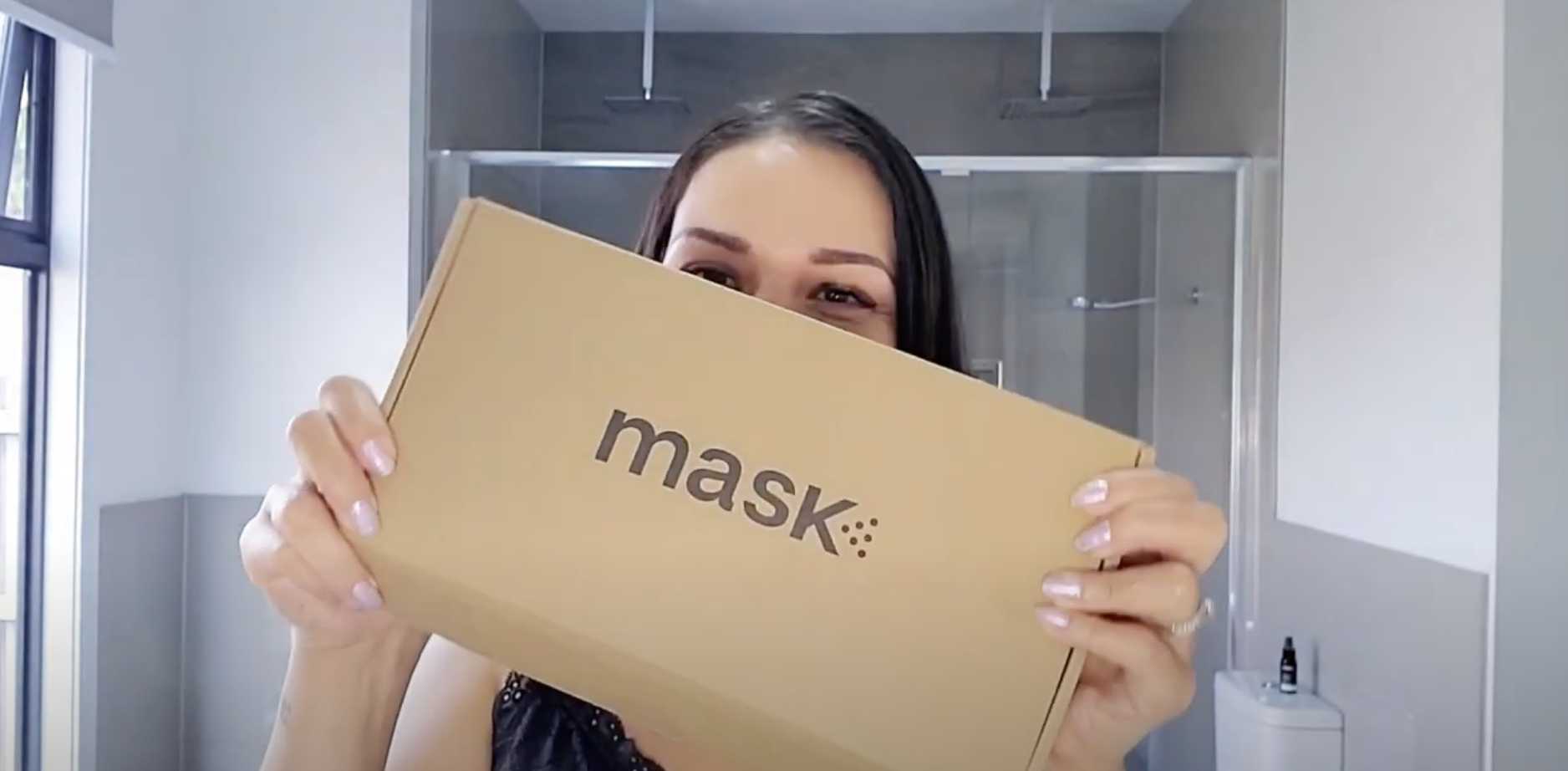 woman showing box of mask c...